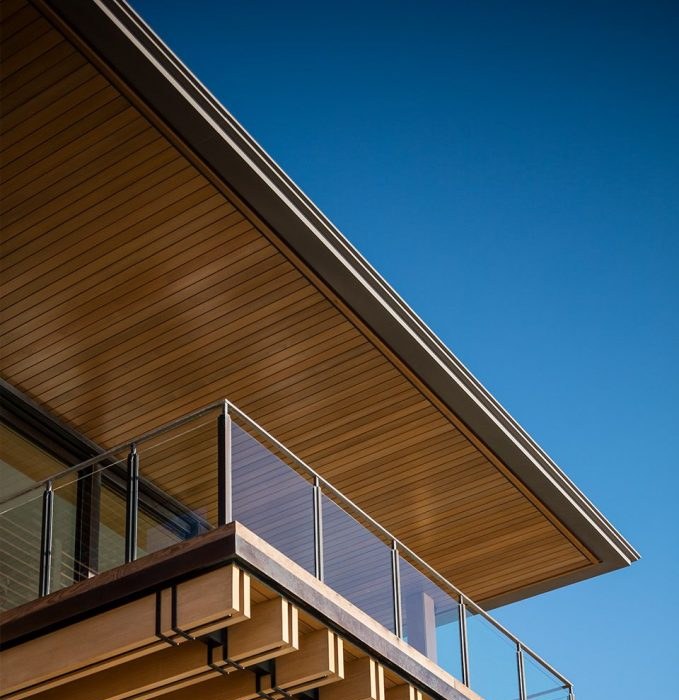 Timber eave and steel balustrade against a clear sky